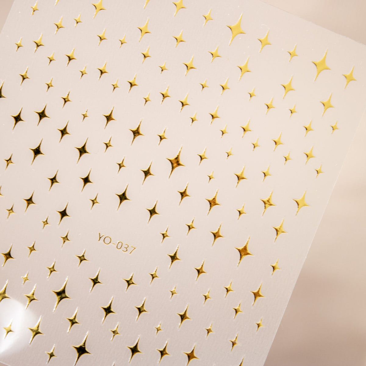 Sheet of metallic gold twinkling star and celestial nail stickers.