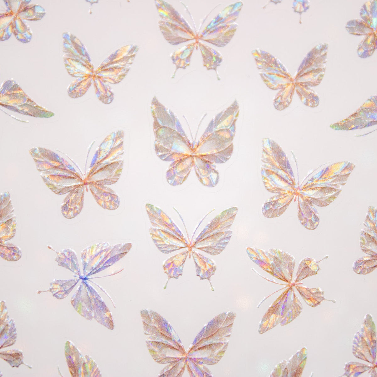 Close-up view of assorted holographic butterfly nail stickers catching light.