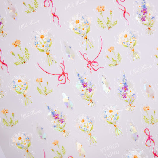 Close-up of watercolor floral nail decals with daisies, lavender, and greenery.