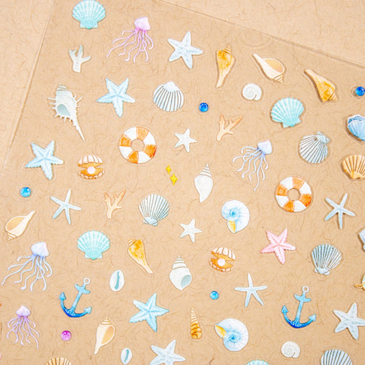 Close-up of ocean nail stickers featuring seashells, starfish, and jellyfish.