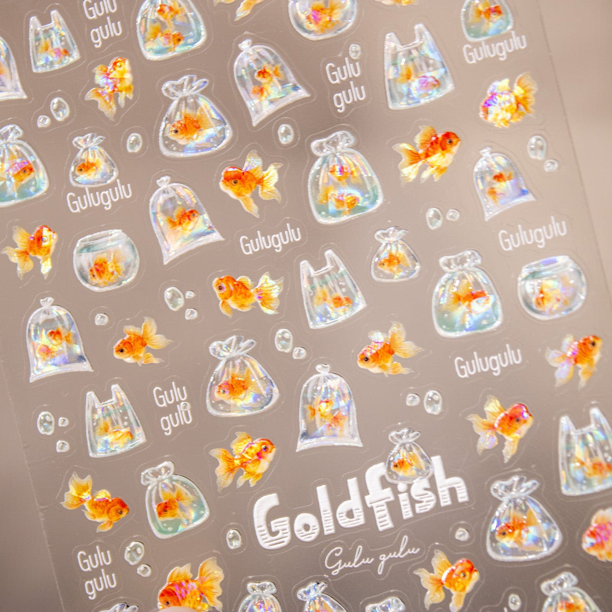 Angled shot showing the Bubbly Goldfish nail sticker sheet.