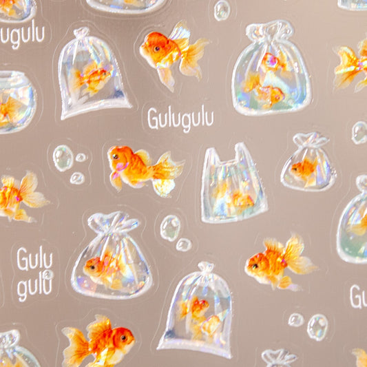 Close-up of goldfish nail decals showing fish in tiny water bags and fishbowls.