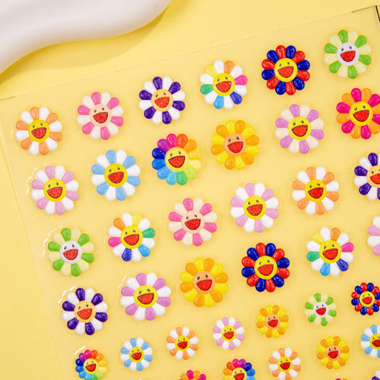 Close-up of cheerful smiley face daisy nail stickers in bright colors.