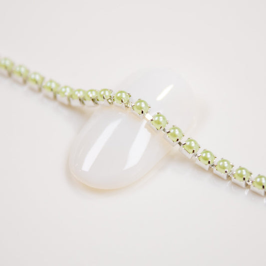 Pastel green 2mm bead chain displayed on a white nail tip.