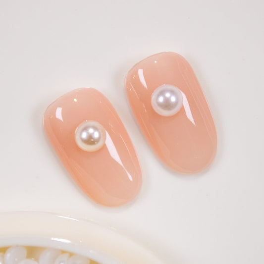 Nude press-on nails styled with delicate flatback half pearls.