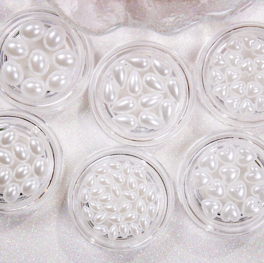 Collection of heart, oval, and teardrop shaped flatback pearls displayed together.