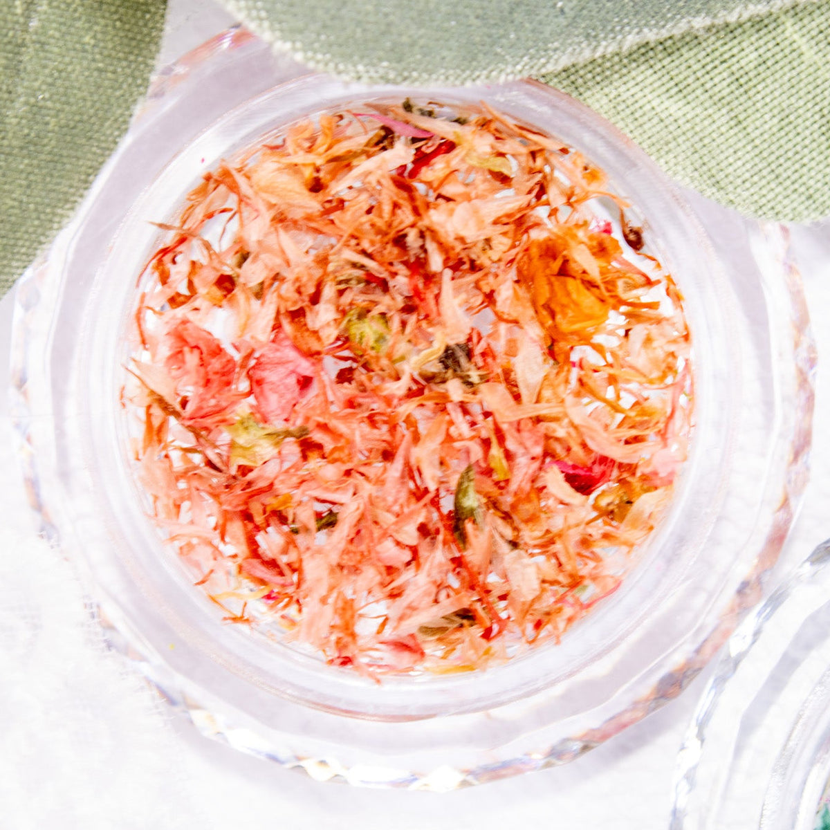 Close-up view of Blush Bloom pressed flower flakes featuring soft coral, blush, and warm floral tones.