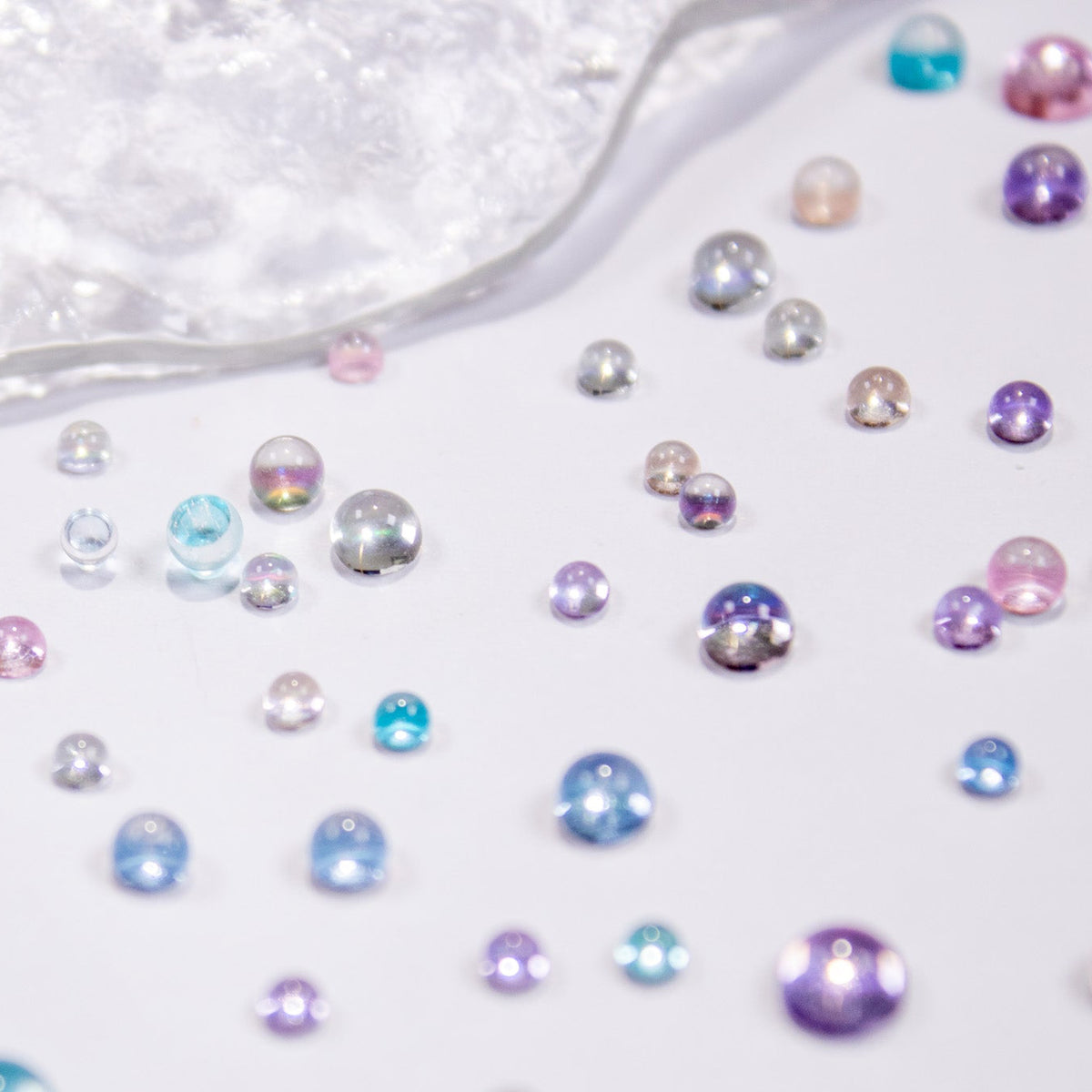Berry Bloom candy drop beads scattered across a textured white surface.