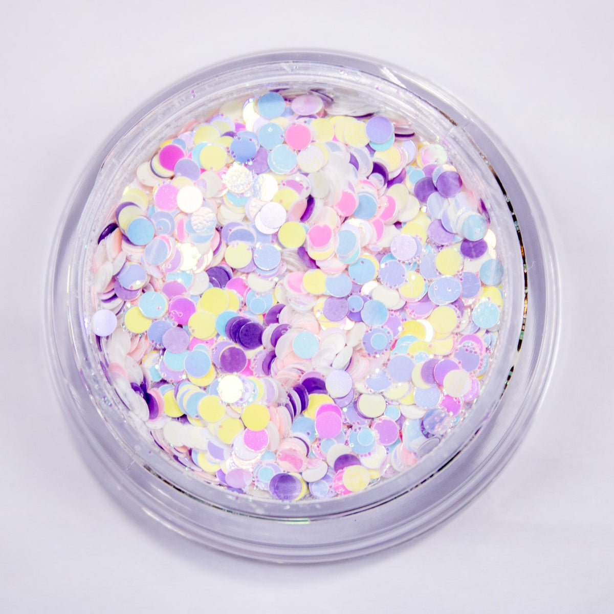 Top-down view of an open jar displaying pastel pink, lilac, blue, and iridescent circle confetti.