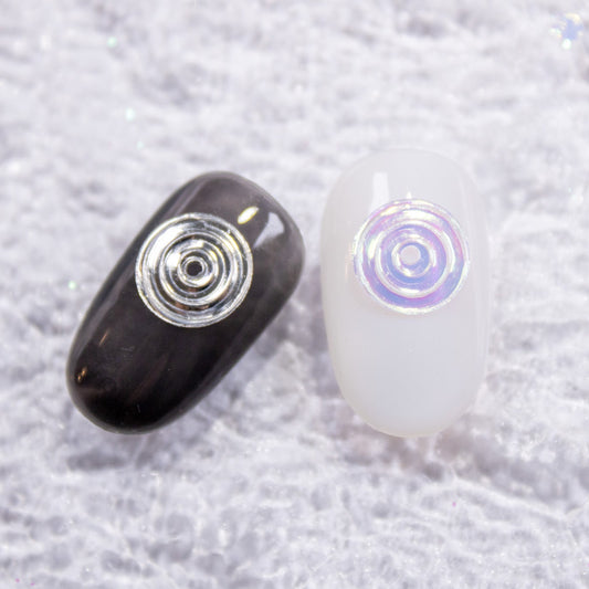 Press-on nails styled with metallic silver and iridescent disco swirl 3D nail charms.