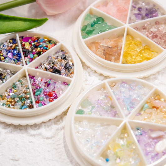Top-down flat lay view of three crystal nail stone wheels displayed side-by-side.