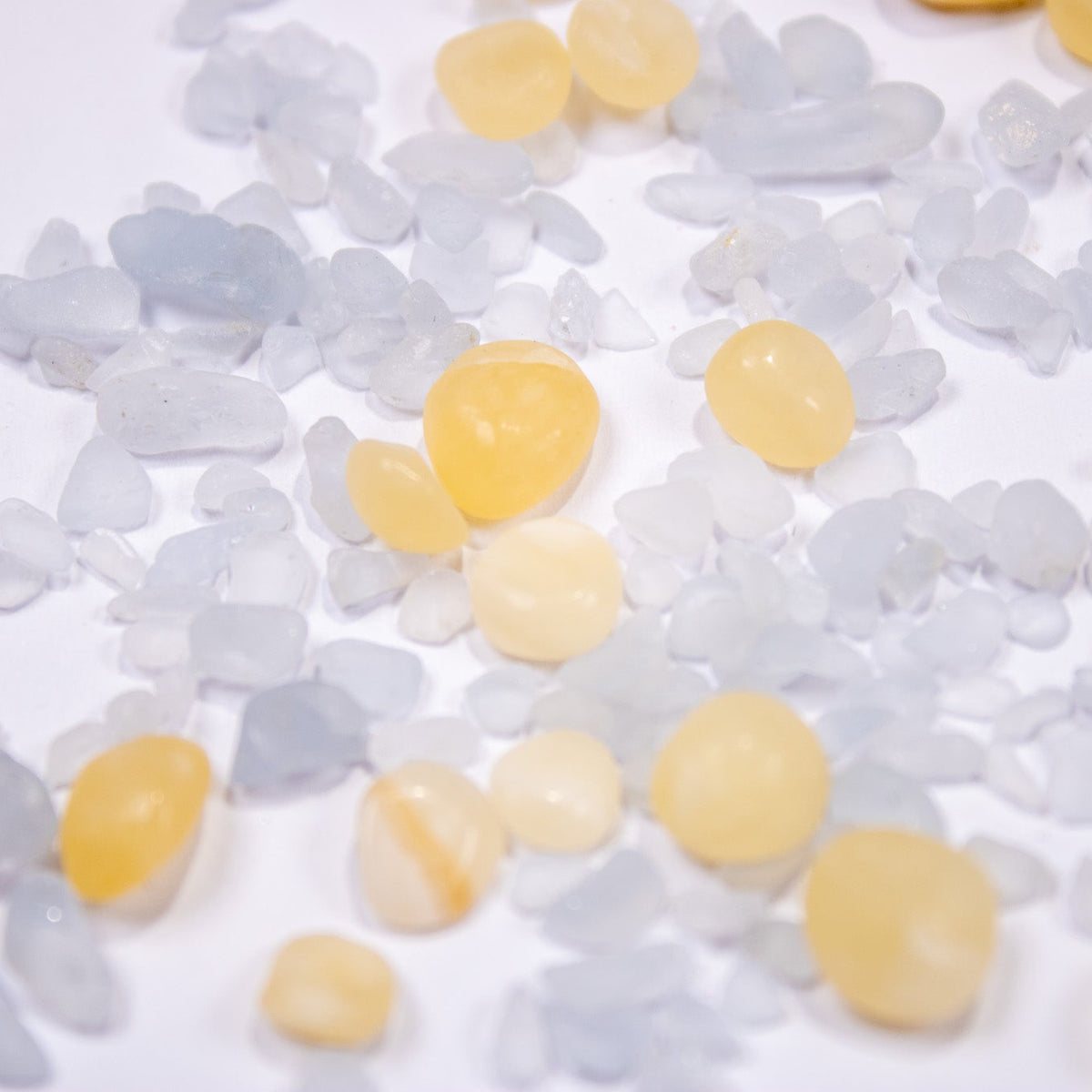 Top-down flat lay of pastel yellow and icy blue organic pebble stones.