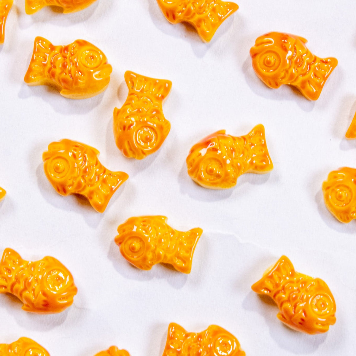 Top-down flat lay grid of multiple mini 3D bungeoppang fish pastry nail charms.