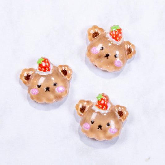 Three mini 3D strawberry-topped bear pie dessert nail charms arranged on a white surface.