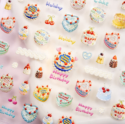 Close-up angled view of a sticker sheet packed with colorful birthday cake nail art decals.