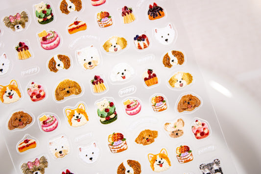 Puppy Cafe nail art sticker sheet resting inside a white ceramic dish highlighting puppy heads and dessert icons.