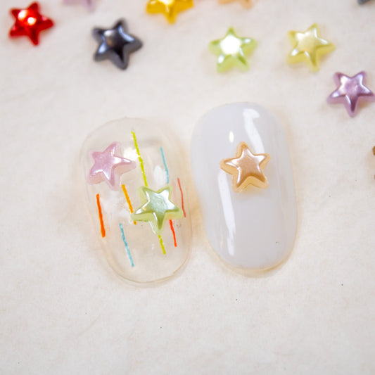Nail swatches featuring white and clear gel bases decorated with colorful mini star charms