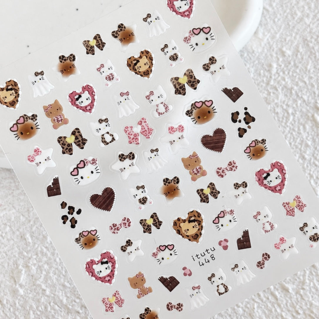 Leopard Kitty nail sticker sheet resting on a white ceramic dish displaying leopard patterns, pink hearts, and chocolate accents.