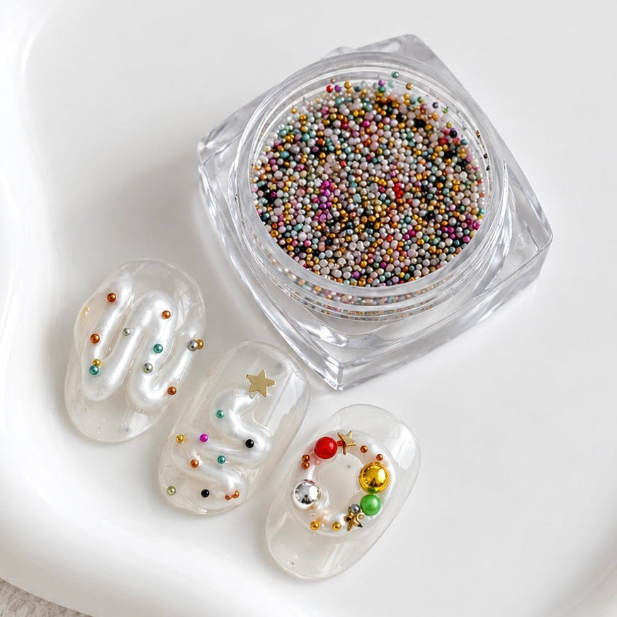 Open square jar of multicolor metallic Stardust Caviar Beads alongside three clear gel nail swatches featuring squiggly gel lines and embedded colorful caviar bead accents.