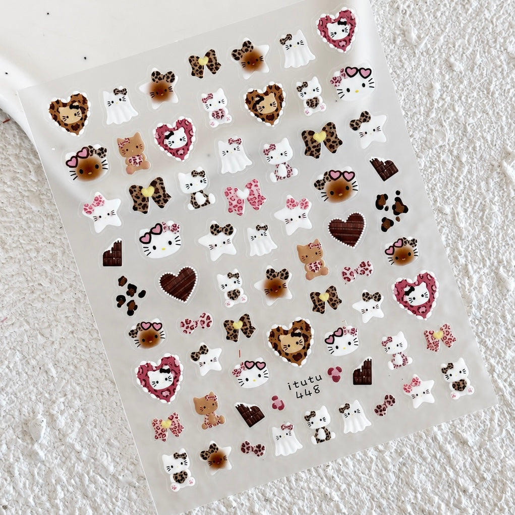Full sheet of Leopard Kitty nail stickers featuring leopard print kitties, pink bows, brown hearts, stars, and chocolate details on a textured white surface.