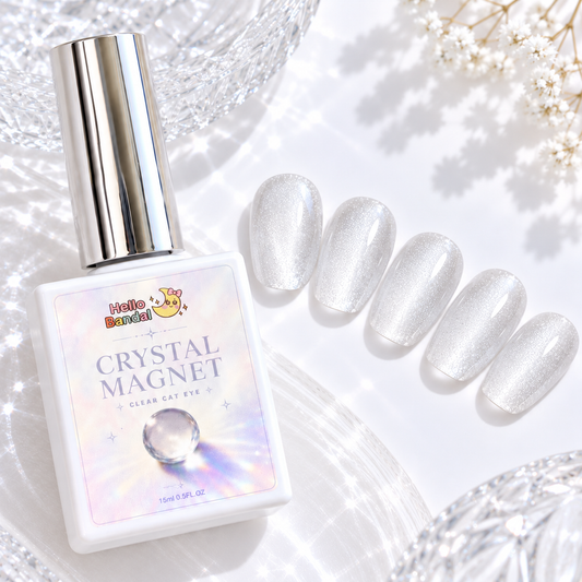 Bottle of Hello Bandal Crystal Magnet Gel next to five oval press-on nail swatches displaying a clear, shimmering magnetic cat eye effect on a white textured background.