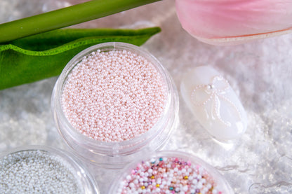 Blush pink micro pearl beads for delicate nail art designs.