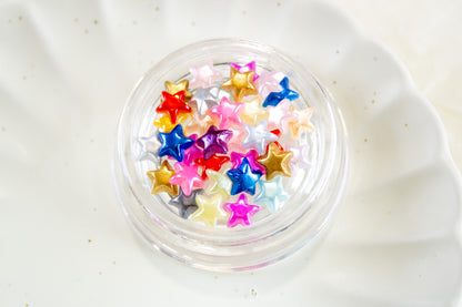 Colorful star nail charms in a jar for DIY nail art and nail decorations.