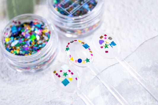 Colorful confetti nail mix with stars, hearts, and shapes used for cute nail art designs.