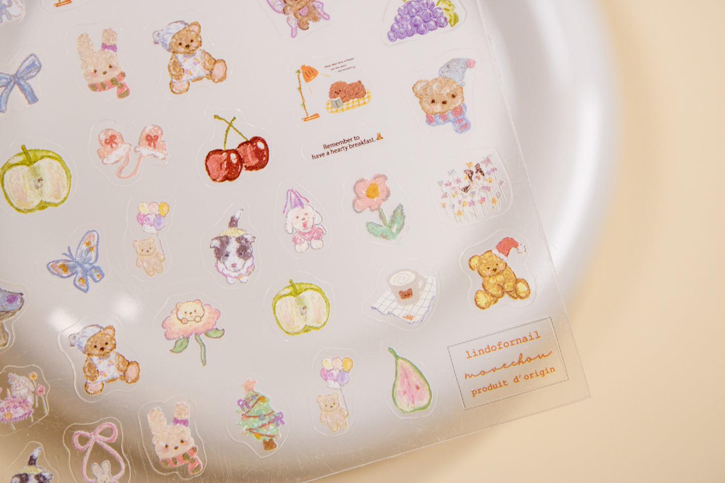 Close-up of cottagecore nail sticker sheet with bears, bunnies, cherries, and ribbon designs.