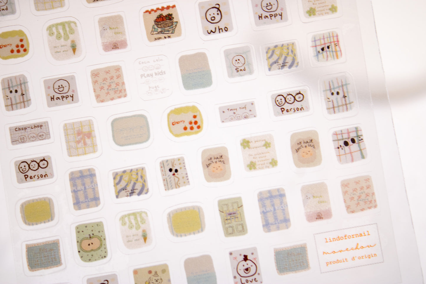 Sheet of kawaii doodle nail stickers with plaid, hearts, smiley faces, and cute hand-drawn nail decals.