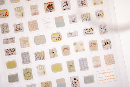 Sheet of kawaii doodle nail stickers with plaid, hearts, smiley faces, and cute hand-drawn nail decals.