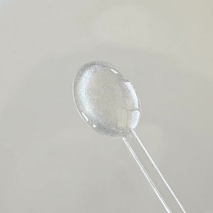 Clear cat eye gel applied onto a clear spoon to showcase the shimmering magnetic glitter effect in motion.