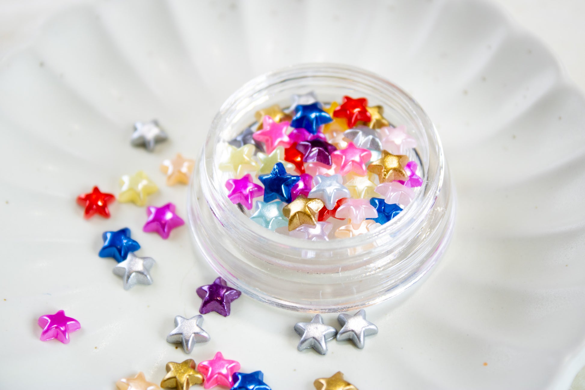 Colorful Y2K star nail charms mix in a jar for cute DIY nail art.