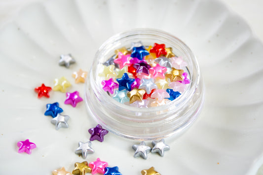 Colorful Y2K star nail charms mix in a jar for cute DIY nail art.